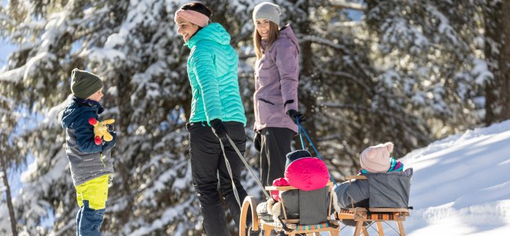 Familie beim Winterwandern mit Rodel am Gerlosstein