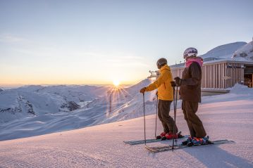 Skifahrer bei Sonnenaufgang auf der Piste in der Zillertal Arena