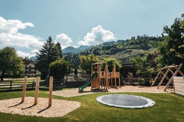 großer Spielplatz mit Trampolin, Rutsche, Klettergerüst und Schaukel