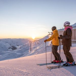 Skifahrer bei Sonnenaufgang auf der Piste in der Zillertal Arena